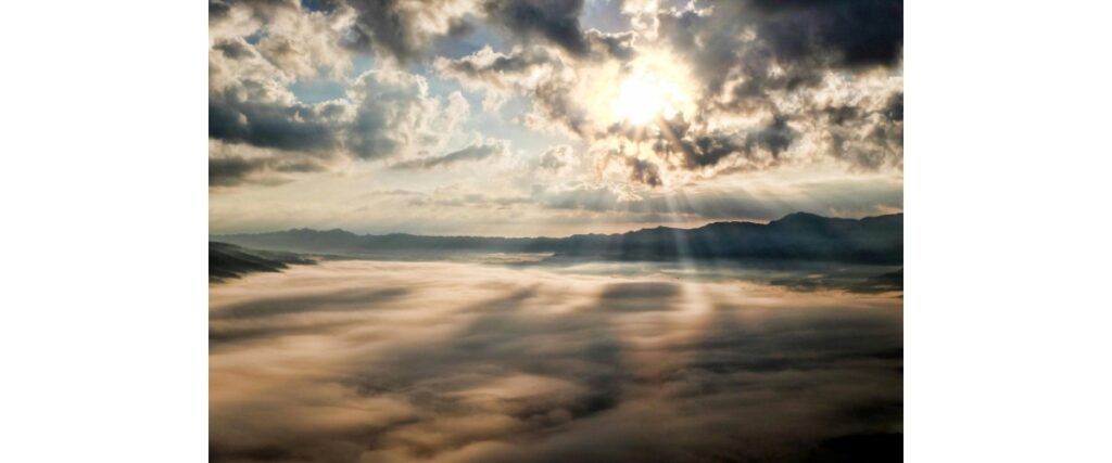 雲の隙間から光が差し込んでいる写真