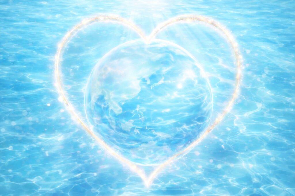 水のように透明な地球を、淡い光のハートが包むイラスト